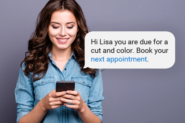Female on cell phone receiving a text notification about her next salon appointment